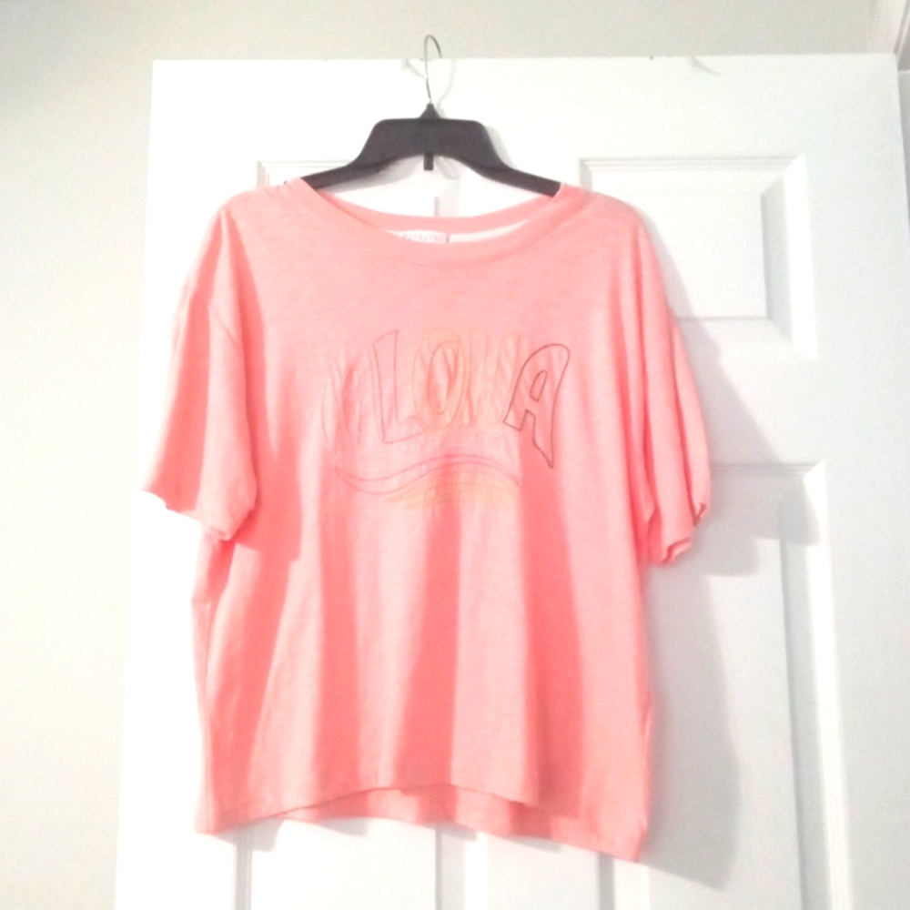 Peach shirt that says ALOHA